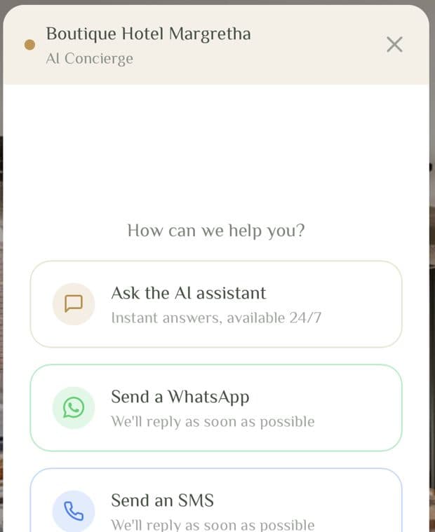 The Lobbiq chat widget open on a hotel's own website, offering three routes: ask the AI assistant, send a WhatsApp, send an SMS.